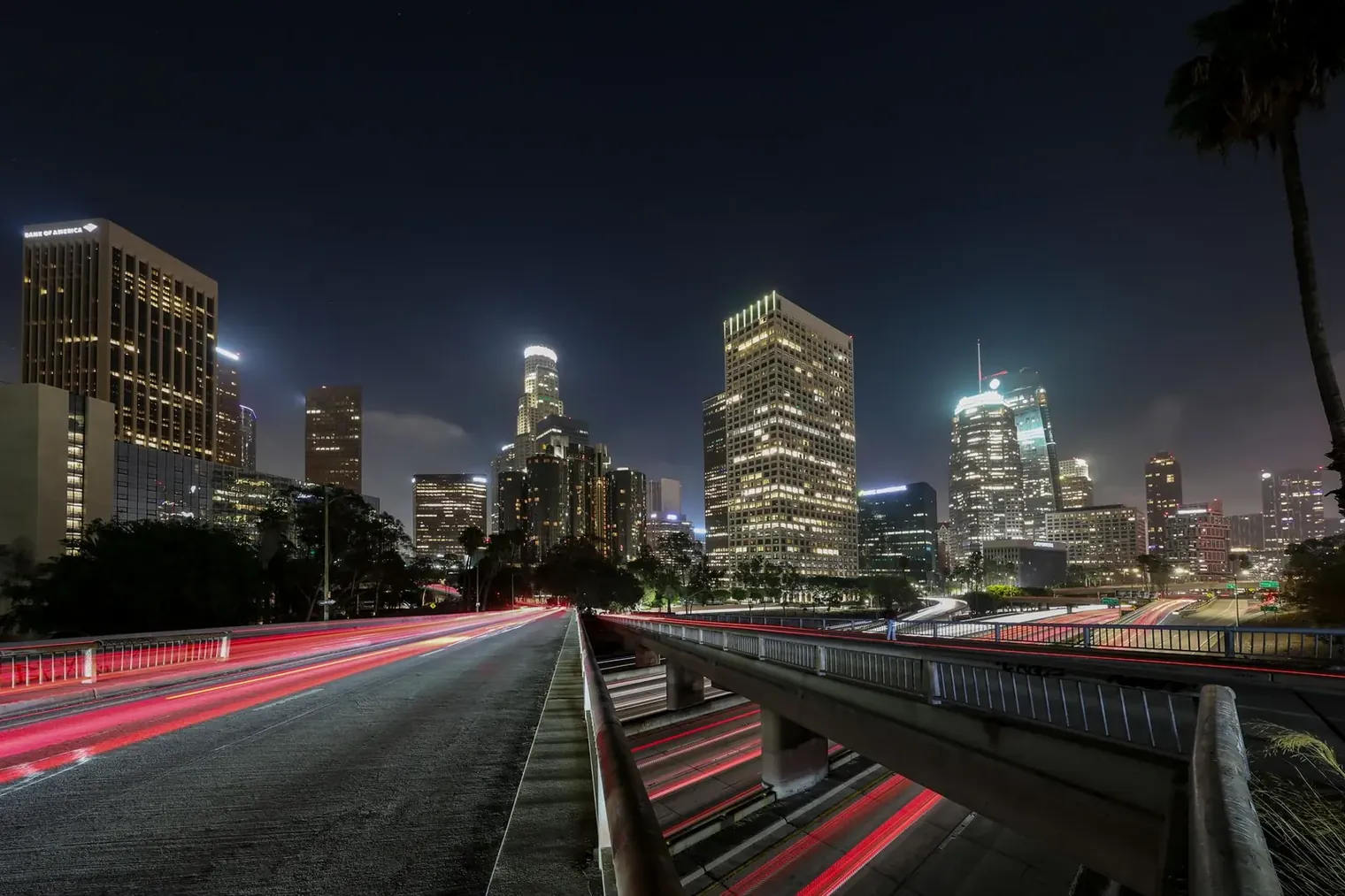 Downtown Los Angeles skyline at night, lit freeways below — the area Nick's Limousine Service covers